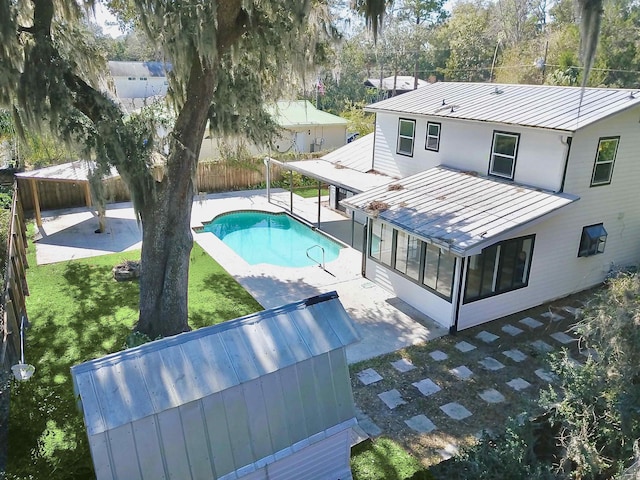 view of swimming pool with a patio area, a sunroom, and a lawn