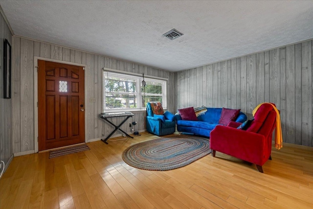 603 Mariposa St, Saint Augustine Beach, FL 32080 - living room with wood finished floors, a textured ceiling, and wood walls