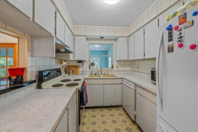 603 Mariposa St, Saint Augustine Beach, FL 32080 - kitchen with white appliances, under cabinet range hood, light countertops, a textured ceiling, and healthy amount of natural light