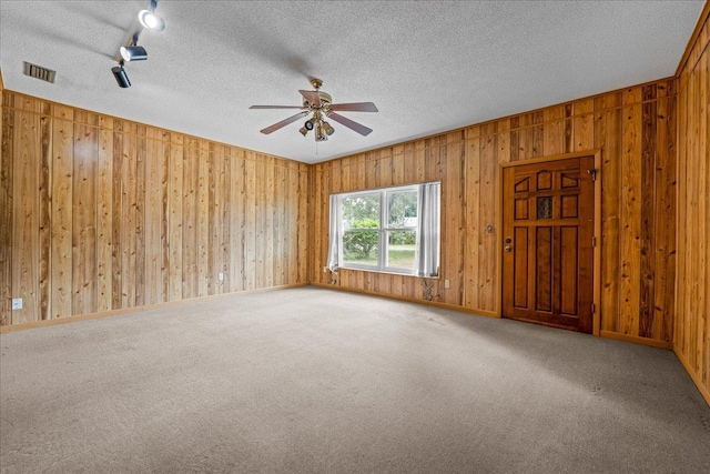 603 Mariposa St, Saint Augustine Beach, FL 32080 - carpeted spare room with a ceiling fan, wood walls, a textured ceiling, and track lighting