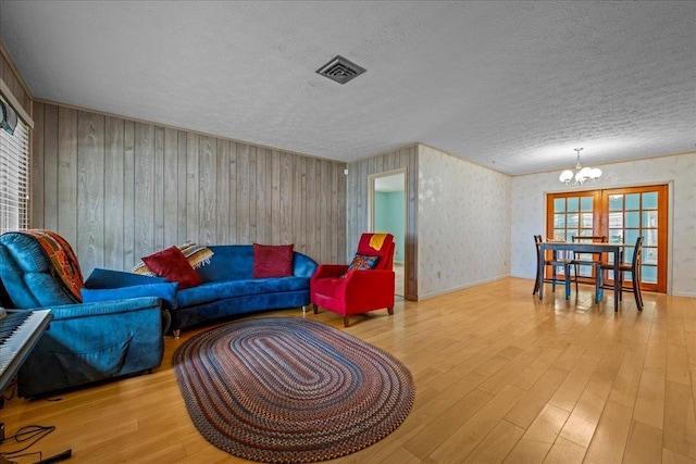603 Mariposa St, Saint Augustine Beach, FL 32080 - living area featuring a chandelier, wood finished floors, and a textured ceiling