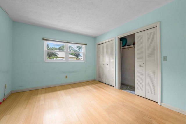 603 Mariposa St, Saint Augustine Beach, FL 32080 - unfurnished bedroom featuring two closets, wood finished floors, and a textured ceiling