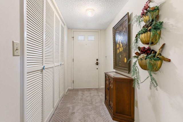 entryway with light carpet and a textured ceiling