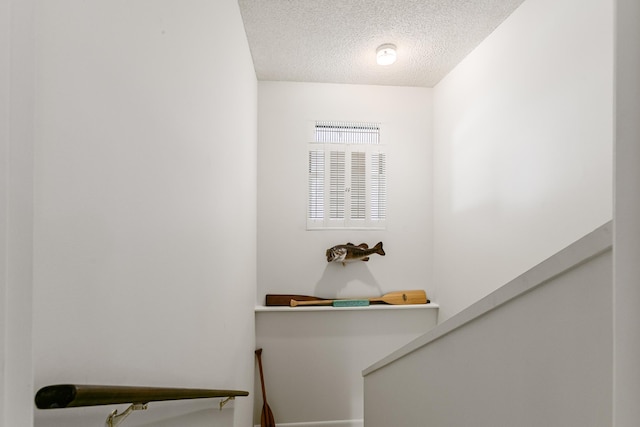 stairway with a textured ceiling