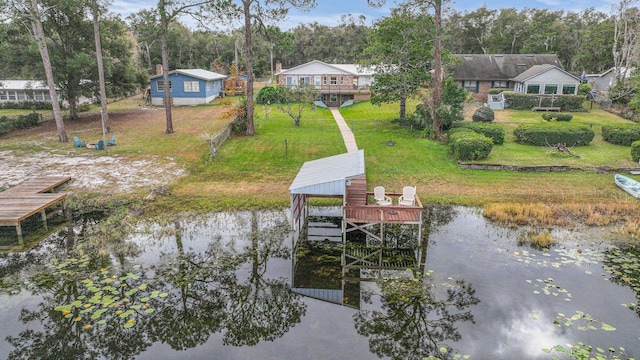 view of dock featuring a lawn and a water view