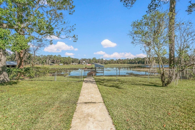 view of dock with a water view and a yard