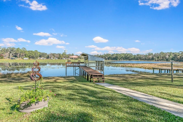 view of dock with a yard and a water view