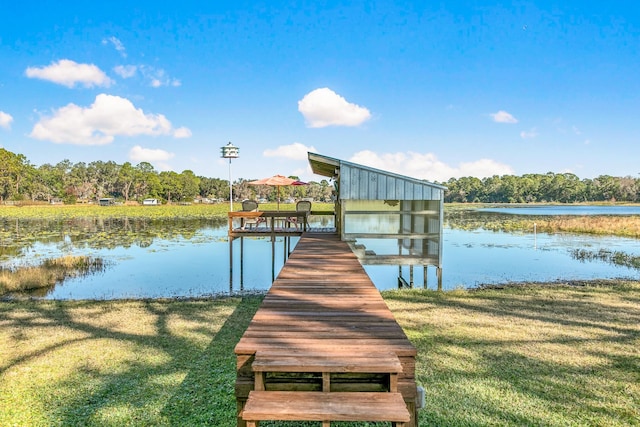 dock area featuring a lawn and a water view