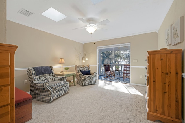 living area featuring carpet flooring, a skylight, ceiling fan, and ornamental molding