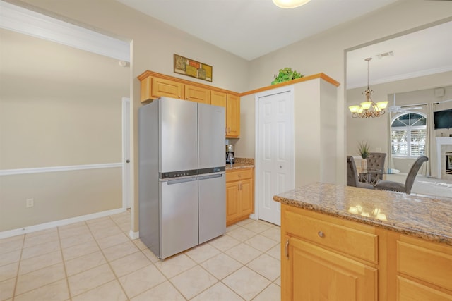 kitchen with stainless steel refrigerator, light stone countertops, light brown cabinets, a chandelier, and light tile patterned floors