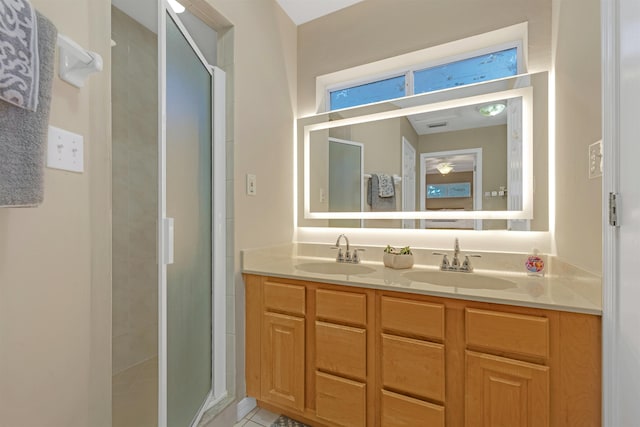 bathroom featuring tile patterned flooring, vanity, and a shower with shower door