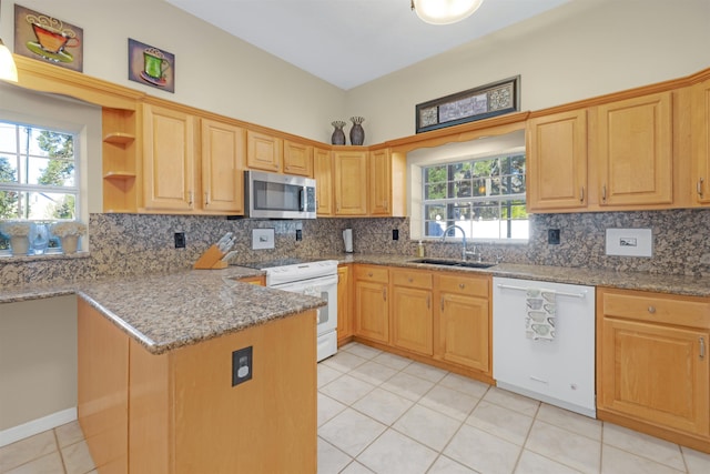 kitchen featuring sink, light stone counters, kitchen peninsula, white appliances, and light tile patterned floors