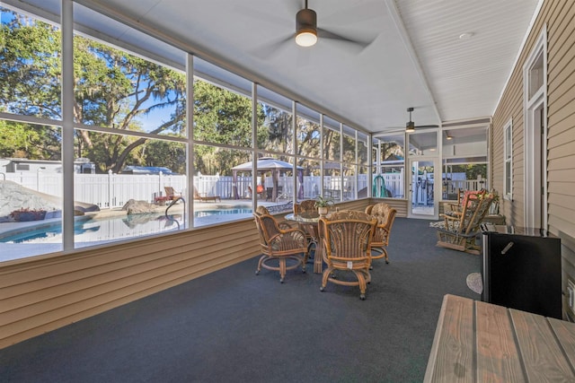 unfurnished sunroom featuring ceiling fan