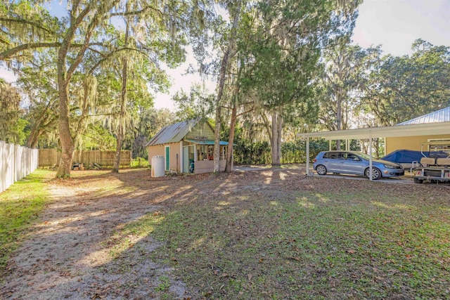 view of yard featuring a carport and an outdoor structure