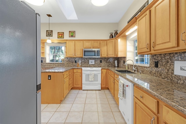 kitchen with light stone countertops, appliances with stainless steel finishes, tasteful backsplash, sink, and pendant lighting