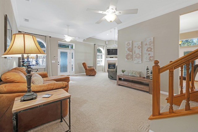 carpeted living room with ceiling fan and crown molding