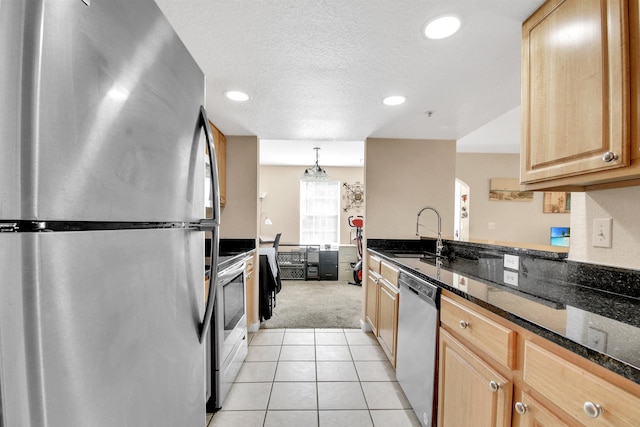 10075 Gate Pkwy Unit 907, Jacksonville, FL 32246 - kitchen with stainless steel appliances, a sink, light brown cabinetry, light colored carpet, and dark stone counters