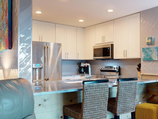 kitchen with white cabinets, stainless steel appliances, and sink