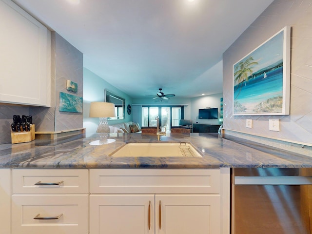 kitchen featuring dark stone counters, sink, ceiling fan, tasteful backsplash, and white cabinetry