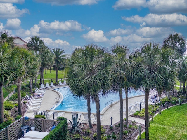 view of swimming pool with a water view and a lawn