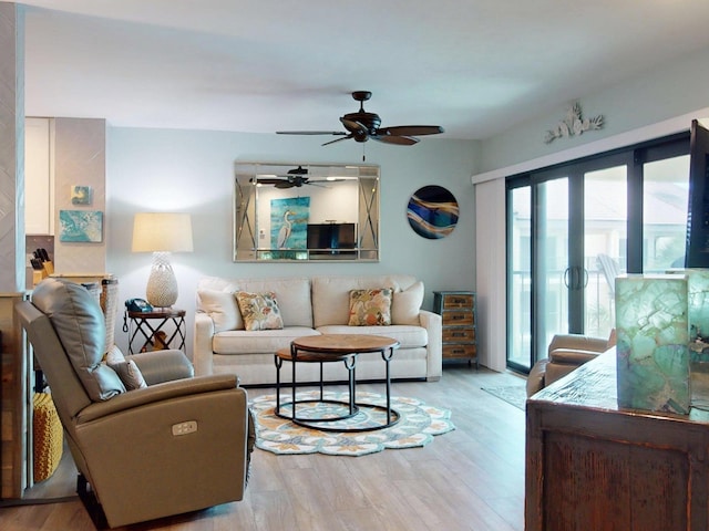 living room with ceiling fan and light hardwood / wood-style flooring