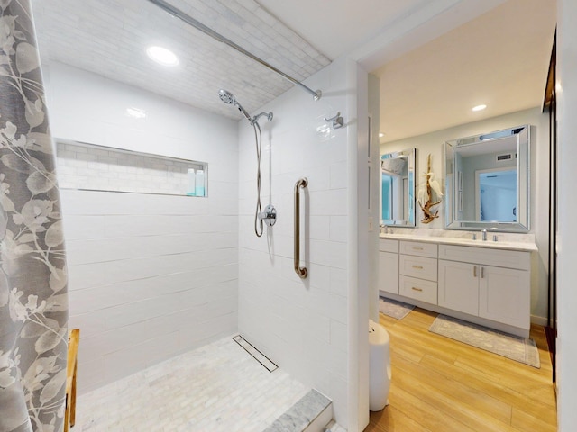 bathroom with hardwood / wood-style floors, vanity, and curtained shower