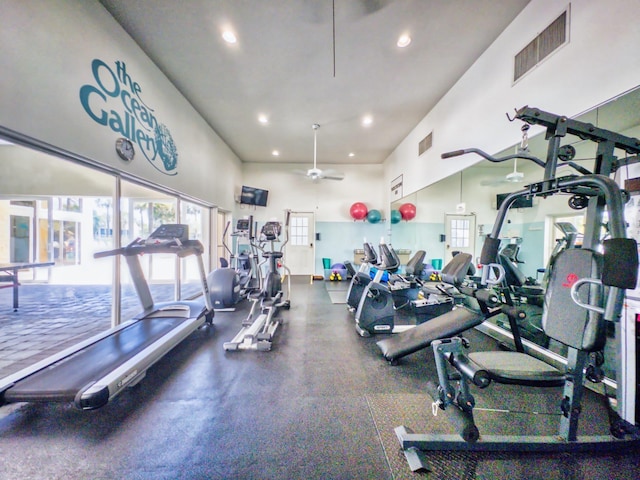 workout area with a towering ceiling and ceiling fan