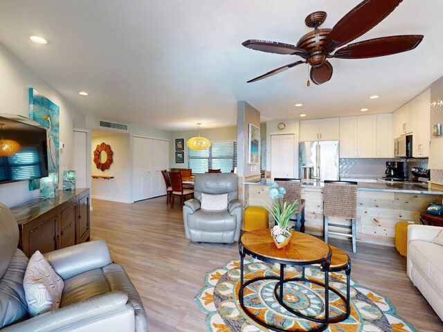 living room featuring ceiling fan and light wood-type flooring