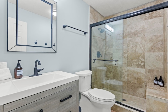 full bathroom with vanity, toilet, and a stall shower