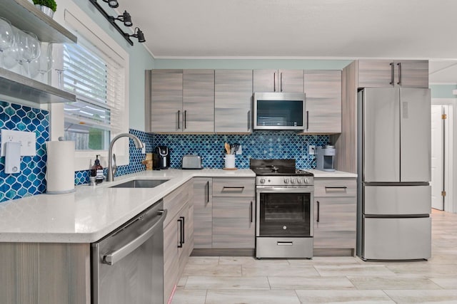 kitchen featuring decorative backsplash, stainless steel appliances, modern cabinets, and a sink