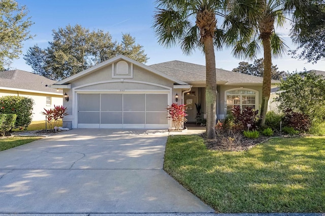 single story home featuring stucco siding, a front lawn, a garage, and driveway