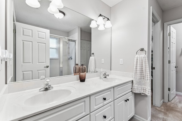 bathroom featuring double vanity, a textured ceiling, a closet, and a sink