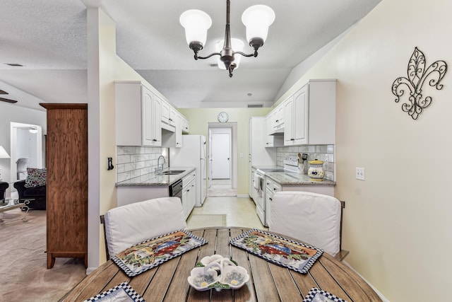 dining room with vaulted ceiling, light carpet, a notable chandelier, and baseboards