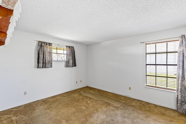 carpeted empty room with a textured ceiling