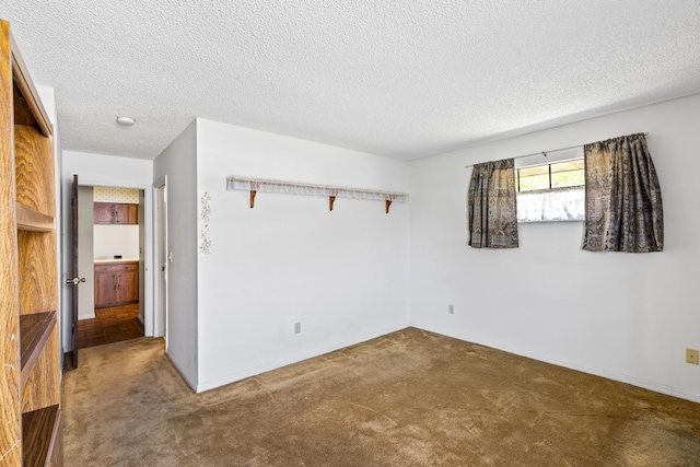 empty room with a textured ceiling and carpet flooring