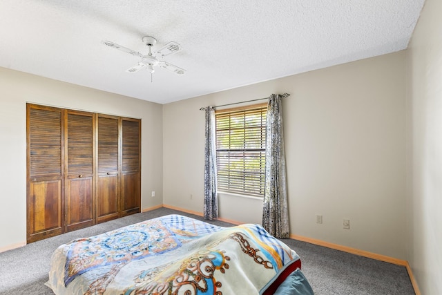 carpeted bedroom with a textured ceiling, a closet, baseboards, and ceiling fan