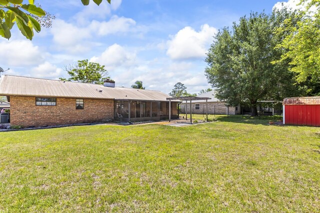 view of yard with a sunroom, an outbuilding, a storage shed, and fence