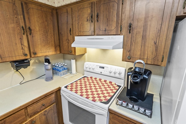 kitchen featuring brown cabinets, white electric stove, ventilation hood, light countertops, and refrigerator