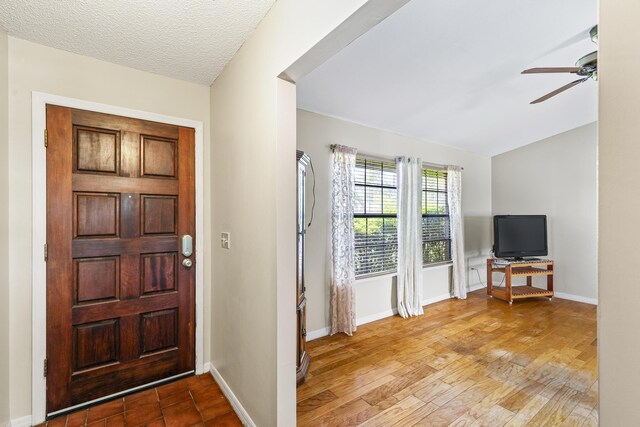 foyer featuring baseboards and ceiling fan
