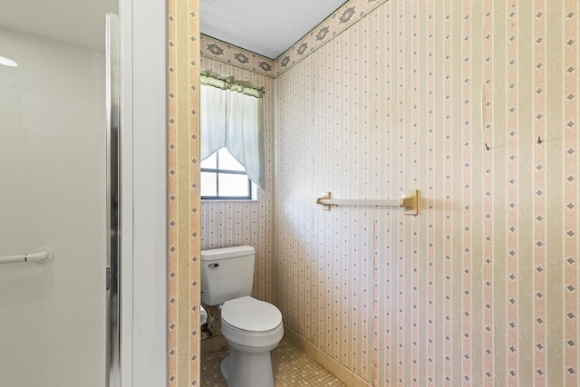 bathroom with wallpapered walls, toilet, and tile patterned floors
