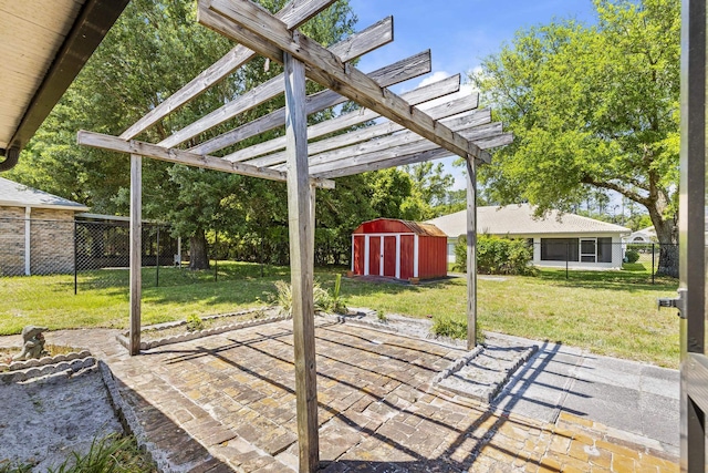 view of patio / terrace with a pergola, fence, an outbuilding, and a storage shed