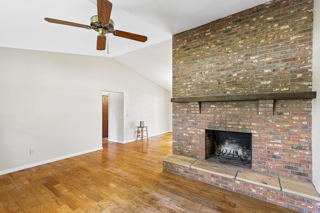unfurnished living room featuring wood finished floors, ceiling fan, baseboards, a fireplace, and lofted ceiling
