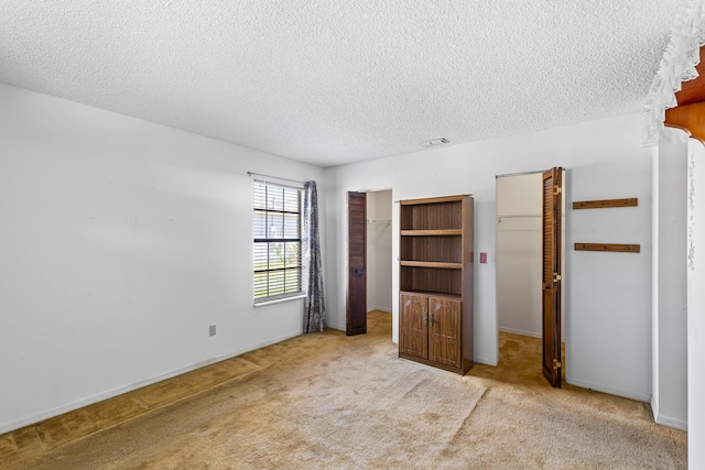 unfurnished bedroom featuring baseboards, a closet, a textured ceiling, and carpet