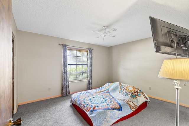 carpeted bedroom featuring a textured ceiling, baseboards, and ceiling fan