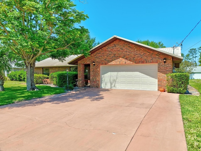ranch-style home with concrete driveway, an attached garage, brick siding, and a front yard