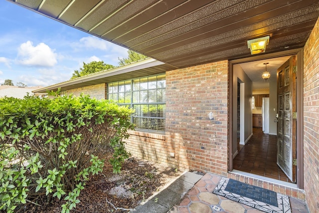 entrance to property featuring brick siding