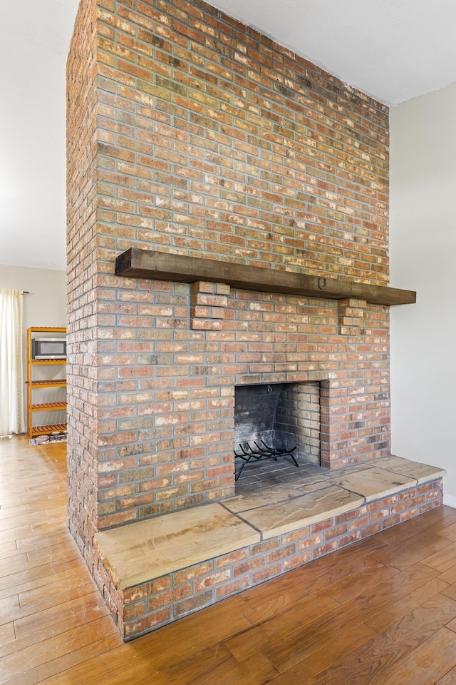room details featuring a brick fireplace and wood finished floors