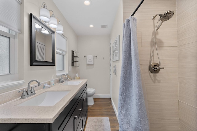 110 Arredondo Ave, Saint Augustine, FL 32080 - full bath with double vanity, a sink, a tile shower, and wood finished floors