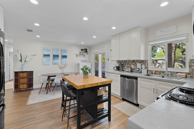 110 Arredondo Ave, Saint Augustine, FL 32080 - kitchen featuring stainless steel dishwasher, light wood-style flooring, and backsplash