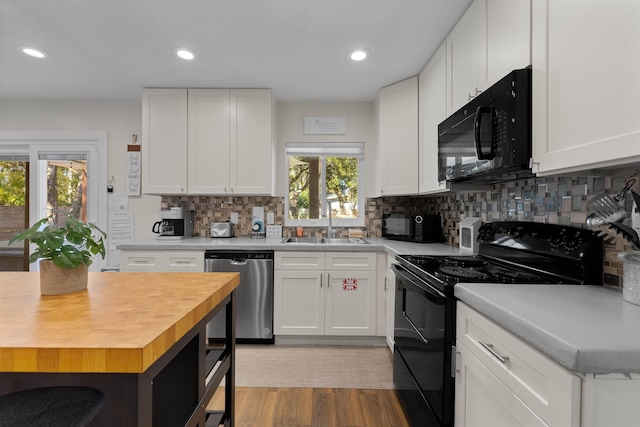 110 Arredondo Ave, Saint Augustine, FL 32080 - kitchen with a sink, white cabinets, tasteful backsplash, butcher block countertops, and black appliances